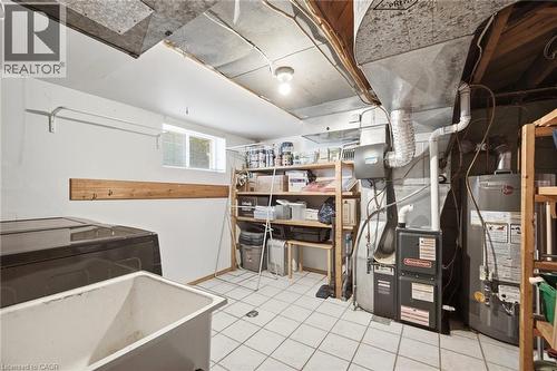 Utility area featuring tiled flooring, a laundry sink, and a high-efficiency furnace - 94 Clarendon Avenue, Hamilton, ON - Indoor