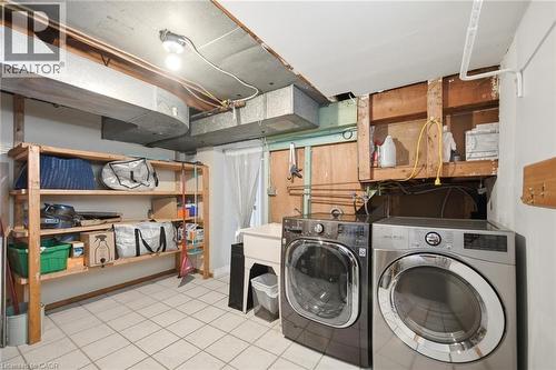 Dedicated laundry area featuring tile flooring, a utility sink, and built-in shelving - 94 Clarendon Avenue, Hamilton, ON - Indoor Photo Showing Laundry Room