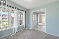 Bright room with light blue walls, featuring a wide window with white sashes and vertical blinds - 