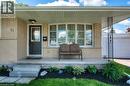 Light-colored brick exterior featuring a covered porch, dark entry door, and a prominent bay window - 61 Bosworth Crescent Unit# Upper, Kitchener, ON  - Outdoor With Deck Patio Veranda 
