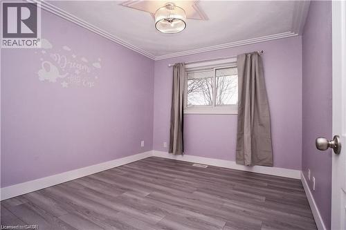 Spacious room featuring wood-finish flooring, white baseboards, and crown molding - 61 Bosworth Crescent Unit# Upper, Kitchener, ON - Indoor Photo Showing Other Room