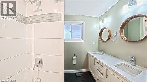 Contemporary bathroom featuring a double vanity with stone countertops, undermount sinks, and chrome fixtures - 61 Bosworth Crescent Unit# Upper, Kitchener, ON - Indoor Photo Showing Bathroom