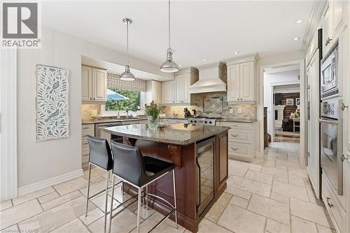 Bright kitchen featuring light-toned cabinetry, granite countertops, and stone tile flooring - 3500 Regal Road, Burlington, ON - Indoor Photo Showing Kitchen With Upgraded Kitchen