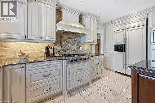 Gourmet kitchen featuring cream-toned cabinetry, granite countertops, and a stone tile backsplash - 3500 Regal Road, Burlington, ON - Indoor Photo Showing Kitchen With Upgraded Kitchen