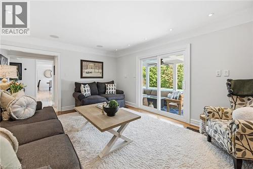 Living area featuring recessed lighting, light wood-finish flooring, and a large sliding glass door opening to an outdoor covered patio - 3500 Regal Road, Burlington, ON - Indoor Photo Showing Living Room