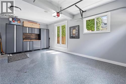 Garage with speckled epoxy flooring, white trim, and built-in gray storage cabinetry - 3500 Regal Road, Burlington, ON - Indoor Photo Showing Other Room