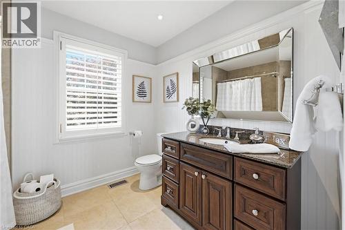 Bathroom featuring a dark wood-finish vanity with a granite countertop, under-mount sink, and framed mirror - 3500 Regal Road, Burlington, ON - Indoor Photo Showing Bathroom