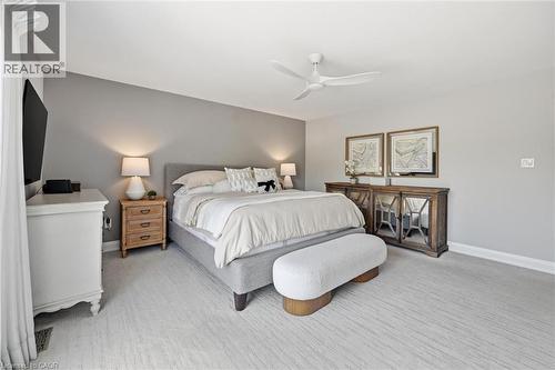 Spacious bedroom featuring light-toned carpeting, a contemporary ceiling fan, baseboard molding, and varied wall tones - 3500 Regal Road, Burlington, ON - Indoor Photo Showing Bedroom