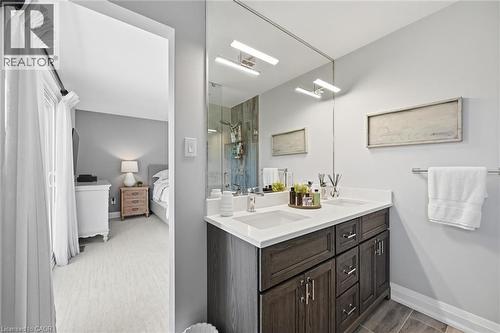 Bathroom featuring a dual-sink vanity with white countertops, dark wood-finish cabinetry, and chrome hardware - 3500 Regal Road, Burlington, ON - Indoor Photo Showing Bathroom