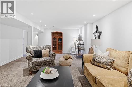Spacious living area featuring neutral carpeting and white painted walls - 3500 Regal Road, Burlington, ON - Indoor Photo Showing Living Room With Fireplace