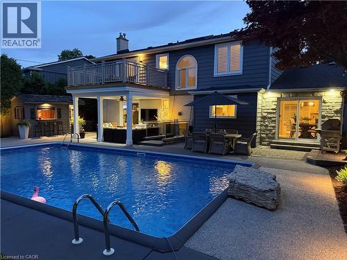 Expansive backyard featuring an in-ground pool, covered patio, outdoor bar shed, and a second-story deck - 3500 Regal Road, Burlington, ON - Outdoor With In Ground Pool With Deck Patio Veranda With Backyard