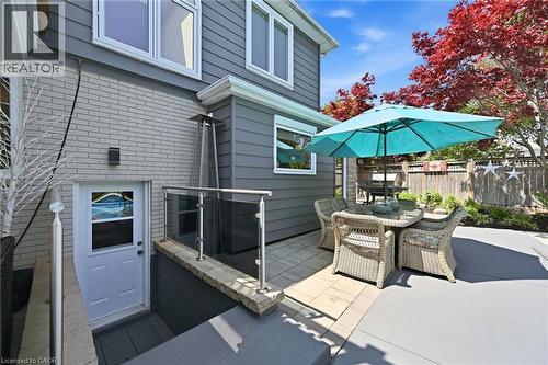 Patio area featuring pavers, an exterior entry, and a glass-paneled railing system - 3500 Regal Road, Burlington, ON - Outdoor With In Ground Pool With Deck Patio Veranda