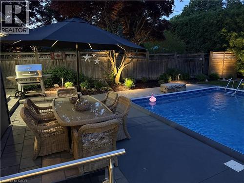 Backyard oasis featuring a swimming pool, paved patio, and perimeter landscaping - 3500 Regal Road, Burlington, ON - Outdoor With Exterior
