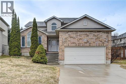 Brick veneer and siding exterior featuring a two-car garage, concrete driveway, and established front landscaping - 519 Yorkshire Drive, Waterloo, ON - Outdoor With Facade