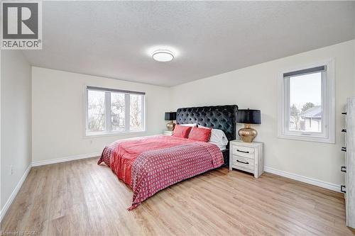 Spacious room featuring wood-finish flooring, light-colored walls, and a contemporary ceiling light fixture - 519 Yorkshire Drive, Waterloo, ON - Indoor Photo Showing Bedroom