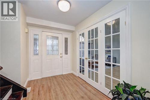 Entryway featuring wood-finish flooring and a white front door with decorative glass inserts - 519 Yorkshire Drive, Waterloo, ON - Indoor Photo Showing Other Room