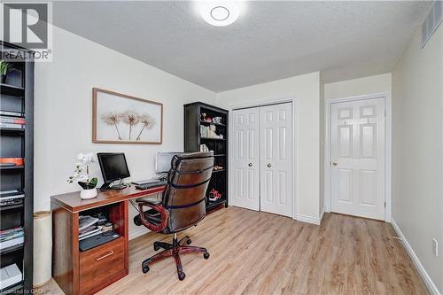 Neutral wall paint, wood-finish flooring, white trim, and a flush mount ceiling light fixture - 519 Yorkshire Drive, Waterloo, ON - Indoor Photo Showing Office