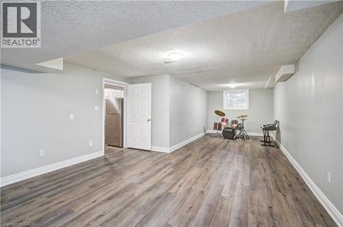 Spacious lower-level room featuring wood-finish flooring, light grey walls, white trim, and recessed lighting - 519 Yorkshire Drive, Waterloo, ON - Indoor Photo Showing Other Room