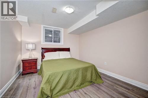Room featuring light-colored walls, wood-finish flooring, a window with blinds, and white baseboards - 519 Yorkshire Drive, Waterloo, ON - Indoor Photo Showing Bedroom