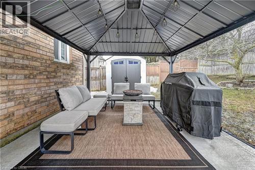Covered concrete patio featuring a metal gazebo, string lighting, and an outdoor area rug - 519 Yorkshire Drive, Waterloo, ON - Outdoor With Deck Patio Veranda With Exterior