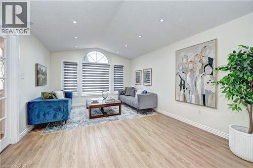 Spacious living area featuring wood-finish flooring, recessed lighting, and a vaulted ceiling with an arched window - 519 Yorkshire Drive, Waterloo, ON - Indoor