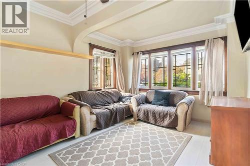 Living area featuring wood-finish flooring, a decorative area rug, and a bay window with natural light - 151 Louisa Street, Kitchener, ON - Indoor Photo Showing Living Room