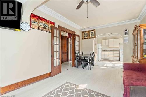 Open-concept living space featuring wood-finish flooring, crown molding, and an arched entryway to the kitchen - 151 Louisa Street, Kitchener, ON - Indoor