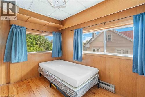 Room featuring wood-finish paneling, wood-finish flooring, and multiple windows - 151 Louisa Street, Kitchener, ON - Indoor Photo Showing Bedroom
