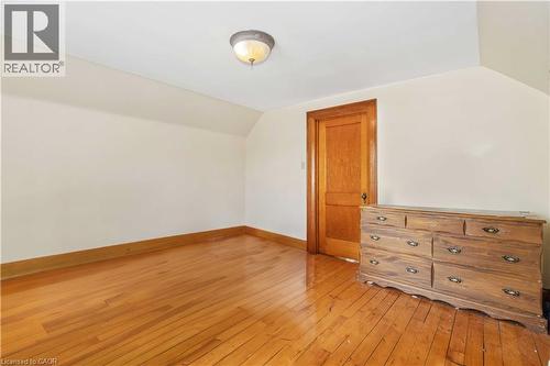 Hardwood flooring, painted walls, wood trim, and a ceiling-mounted light fixture - 151 Louisa Street, Kitchener, ON - Indoor Photo Showing Other Room