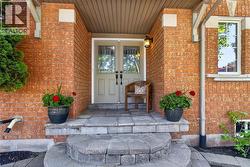 Brick exterior featuring a covered entry, double entry doors with decorative glass, and a stone paver pathway - 