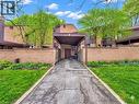 Brick exterior with a covered carport entrance, surrounded by established landscaping and mature trees - 28 Underhill Crescent Unit# 3, Kitchener, ON  - Outdoor 