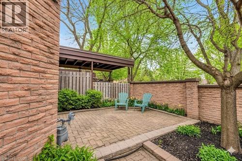 Expansive brick paver patio featuring a partial pergola, brick retaining walls, and surrounding landscaping - 28 Underhill Crescent Unit# 3, Kitchener, ON - Outdoor