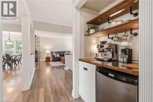 Integrated coffee bar featuring wood-finish shelving, under-shelf lighting, a wood-finish countertop, and a built-in beverage refrigerator - 2207 Jester Court, Burlington, ON - Indoor
