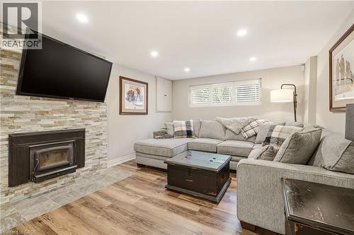 Living area featuring a stone veneer fireplace with a wood-burning insert - 2207 Jester Court, Burlington, ON - Indoor Photo Showing Living Room With Fireplace
