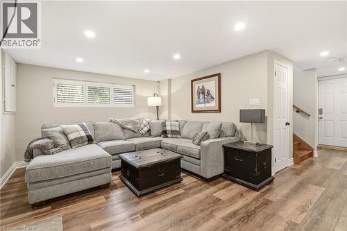 Spacious recreation room featuring wood-finish flooring, recessed lighting, and white plantation shutters - 2207 Jester Court, Burlington, ON - Indoor Photo Showing Living Room