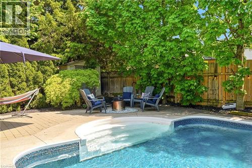 Outdoor swimming pool with built-in steps and mosaic tile accents - 2207 Jester Court, Burlington, ON - Outdoor With In Ground Pool With Backyard