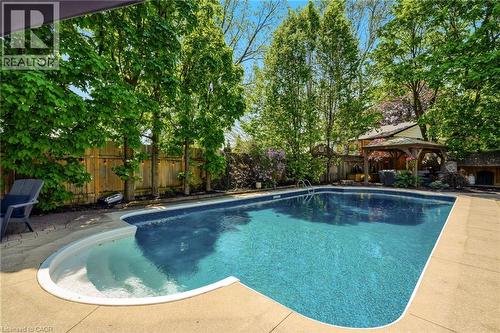 Backyard oasis featuring an in-ground swimming pool with integrated steps, surrounded by concrete decking - 2207 Jester Court, Burlington, ON - Outdoor With In Ground Pool With Backyard