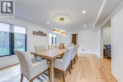 Spacious interior featuring wide-plank wood-finish flooring, recessed lighting, and a decorative ceiling medallion - 54 Deerview Avenue, Ancaster, ON - Indoor Photo Showing Dining Room