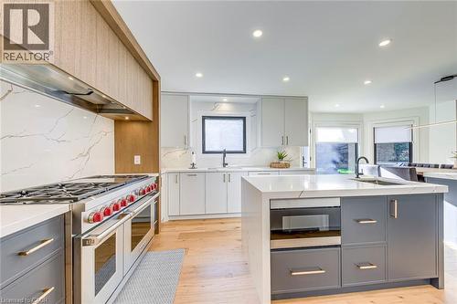 Contemporary kitchen featuring light wood-finish flooring, recessed lighting, and a large central island - 54 Deerview Avenue, Ancaster, ON - Indoor Photo Showing Kitchen With Upgraded Kitchen