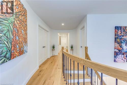 Hallway featuring wood-finish flooring, recessed lighting, and white paneled doors with black hardware - 54 Deerview Avenue, Ancaster, ON - Indoor Photo Showing Other Room
