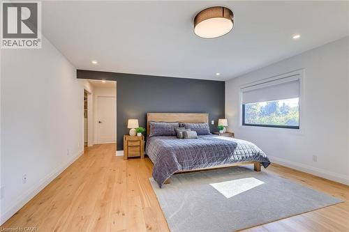 Spacious room featuring light wood-finish flooring, recessed lighting, and a modern drum ceiling fixture - 54 Deerview Avenue, Ancaster, ON - Indoor Photo Showing Bedroom