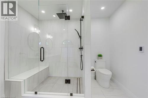Glass-enclosed shower featuring a built-in bench, black matte fixtures, and recessed lighting - 54 Deerview Avenue, Ancaster, ON - Indoor Photo Showing Bathroom