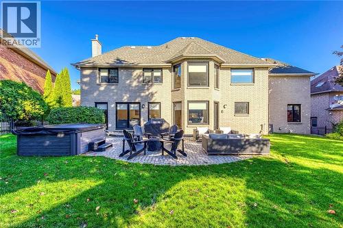Rear exterior featuring light-colored brick construction and multiple windows - 54 Deerview Avenue, Ancaster, ON - Outdoor