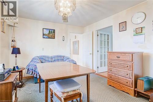 Carpeted room featuring a ceiling-mounted light fixture, white walls, and a wood-finish door with glass panels - 186 Adeline Avenue, Hamilton, ON - Indoor Photo Showing Other Room