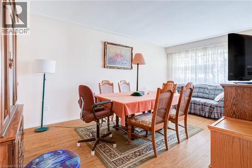 Open concept room featuring wood-finish flooring, light-colored walls, and a large window with sheer white coverings - 186 Adeline Avenue, Hamilton, ON - Indoor Photo Showing Dining Room
