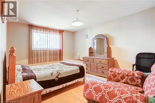 Bedroom featuring light wood-finish flooring and a single window with vertical blinds - 186 Adeline Avenue, Hamilton, ON - Indoor Photo Showing Bedroom