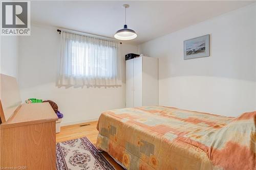 Bedroom featuring light wood-finish flooring, white walls, and a window with sheer curtains - 186 Adeline Avenue, Hamilton, ON - Indoor Photo Showing Bedroom