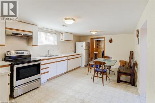 Kitchen featuring white cabinetry with wood-finish accents, a stainless steel range, and a double basin sink - 186 Adeline Avenue, Hamilton, ON - Indoor Photo Showing Kitchen With Double Sink