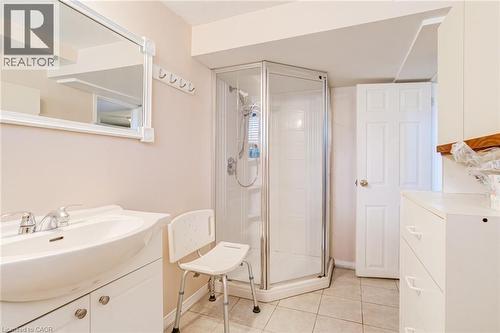 Bathroom featuring a glass-enclosed corner shower, a vanity with an integrated sink, and a framed wall mirror - 186 Adeline Avenue, Hamilton, ON - Indoor Photo Showing Bathroom
