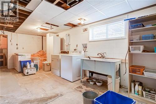 Utility area featuring a double basin utility sink, white tiled backsplash, and a window with blinds - 186 Adeline Avenue, Hamilton, ON - Indoor Photo Showing Laundry Room